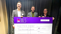 Two men and a lady holding a giant cheque