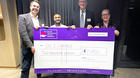A group of men and women holding a giant cheque