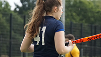 The back of a female playing hockey
