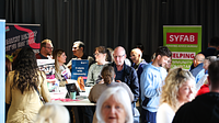 Male and female adults walking around a room with pop up banners