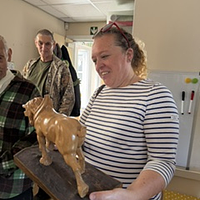 A lady holding a carved lion
