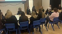 A group of teenage school girls sat around a table
