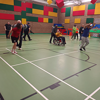 Young people and adults playing in a colourful sports hall