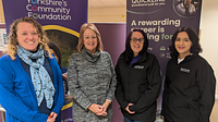 A group of four women stood in a line in front of a SYCF pop up banner and Quickline pop up banner