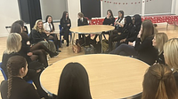 A group of teenage school girls sat around a table
