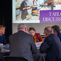 image on individuals sat round a table having a discussion