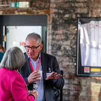 a close of of two attendees talking.