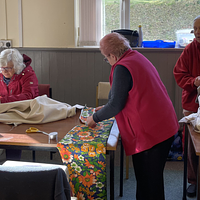 Three women sewing at a table
