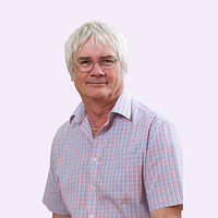 A man wearing a shirt and glasses, smiling